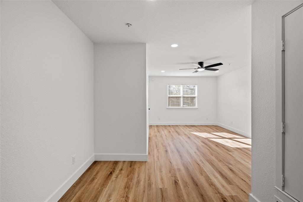 125 13th Street Southeast, Unit 201 Paris, TX 75460 - Photo 10 of 11 a view of an empty room with wooden floor and a window