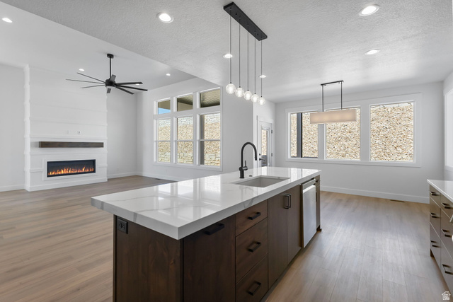 710 East Mountain Road North Ogden, UT 84414 - Photo 4 of 36 Kitchen with dark brown cabinetry, pendant lighting, a textured ceiling, an island with sink, and ceiling fan
