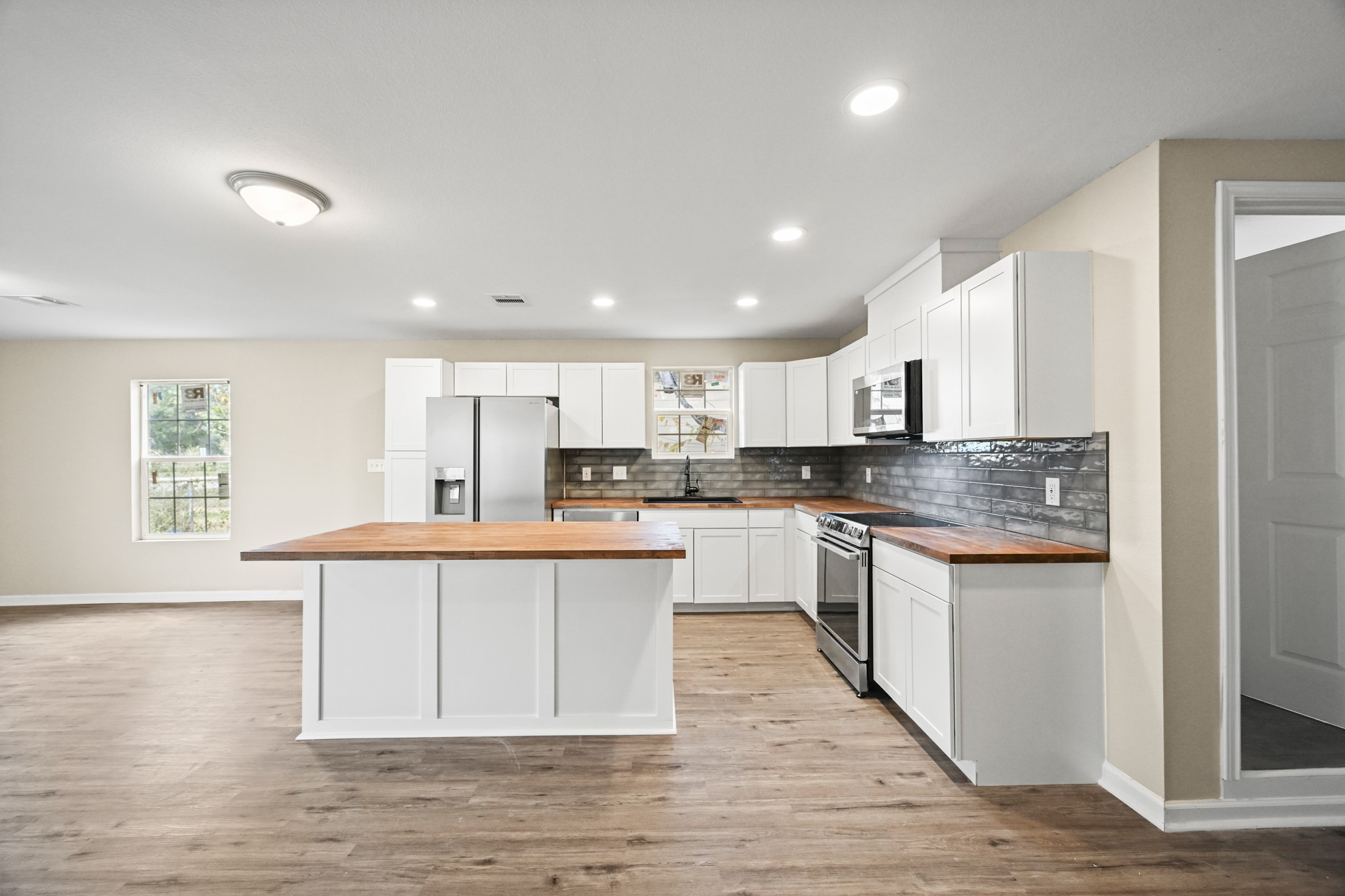 1007 Gazin Street Houston, TX 77020 - Photo 2 of 29 a large white kitchen with stainless steel appliances granite countertop a stove a sink dishwasher and a oven with cabinets