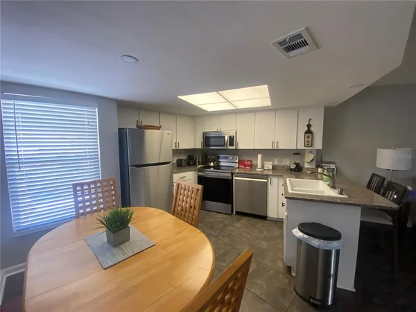 a kitchen with a sink a kitchen island and stainless steel appliances