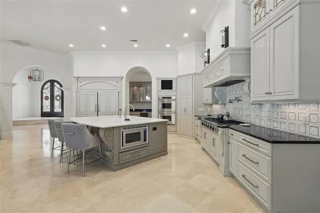 a living room with furniture kitchen view and a chandelier