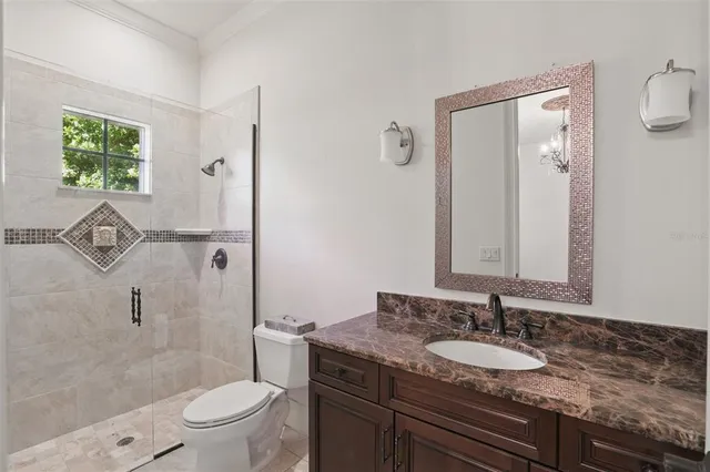 an empty room with wooden floor chandelier and windows