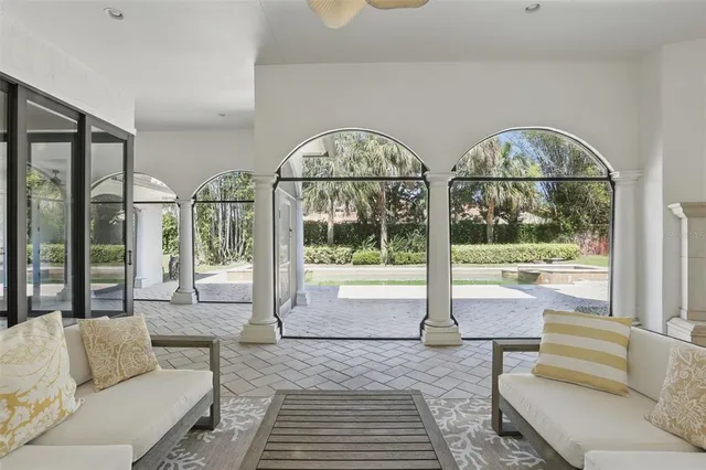 a living room with furniture a chandelier and a large window