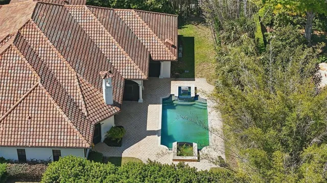 an aerial view of a house with a yard and trees