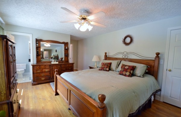 57 Green Road Bolton, MA 01740 - Photo 11 of 28 a bedroom with a large bed and a chandelier