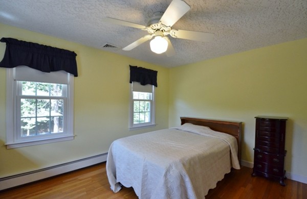57 Green Road Bolton, MA 01740 - Photo 16 of 28 a bedroom with a bed and a chandelier