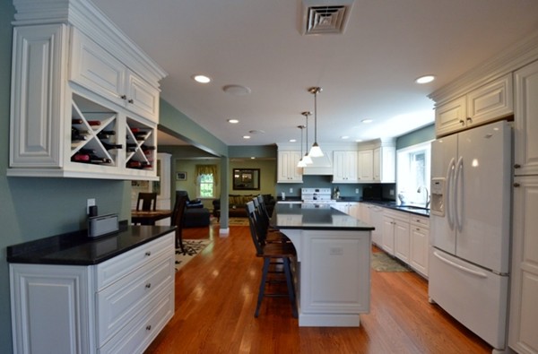 57 Green Road Bolton, MA 01740 - Photo 2 of 28 a kitchen with stainless steel appliances granite countertop a refrigerator a oven a stove and white cabinets with wooden floor