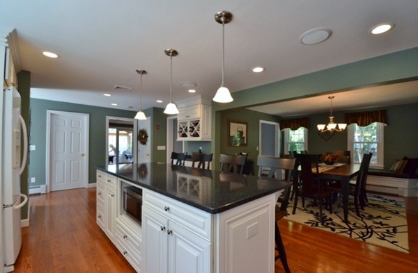 57 Green Road Bolton, MA 01740 - Photo 4 of 28 a kitchen with granite countertop a stove a sink a dining table and chairs with wooden floor