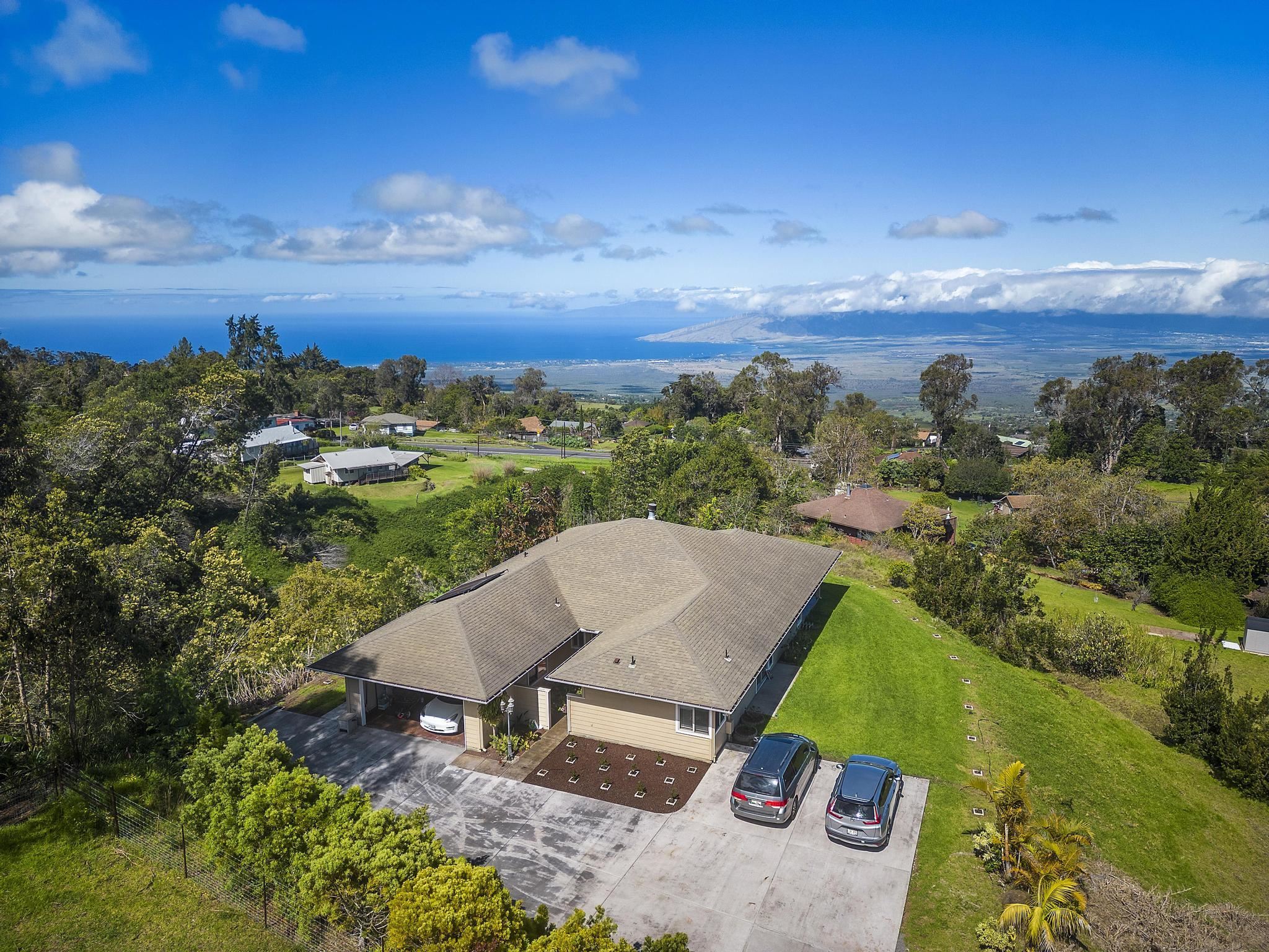 an aerial view of a house with yard and ocean view