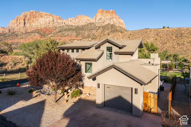 101 Chuckwalla Lane Springdale, UT 84767 - Photo 2 of 51 View of front facade featuring a garage, stucco siding, concrete driveway, and a mountain view