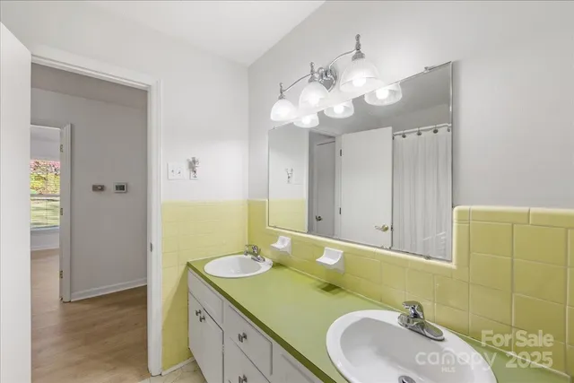 a bathroom with a double vanity sink mirror and shower