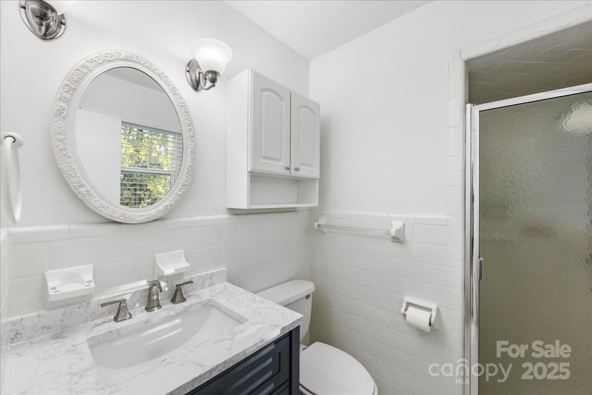 1840 Stoneyridge Drive Charlotte, NC 28214 - Photo 13 of 44 a bathroom with a granite countertop toilet sink and mirror