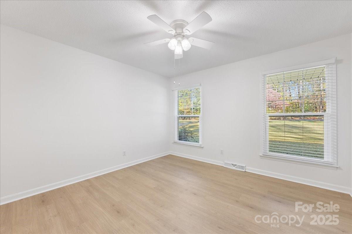 1840 Stoneyridge Drive Charlotte, NC 28214 - Photo 15 of 44 an empty room with a window and a ceiling fan
