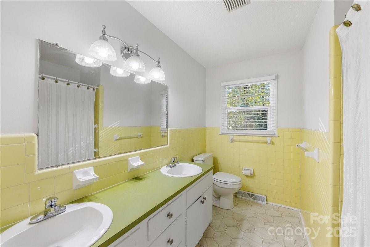 1840 Stoneyridge Drive Charlotte, NC 28214 - Photo 10 of 44 a bathroom with a double vanity sink mirror and toilet