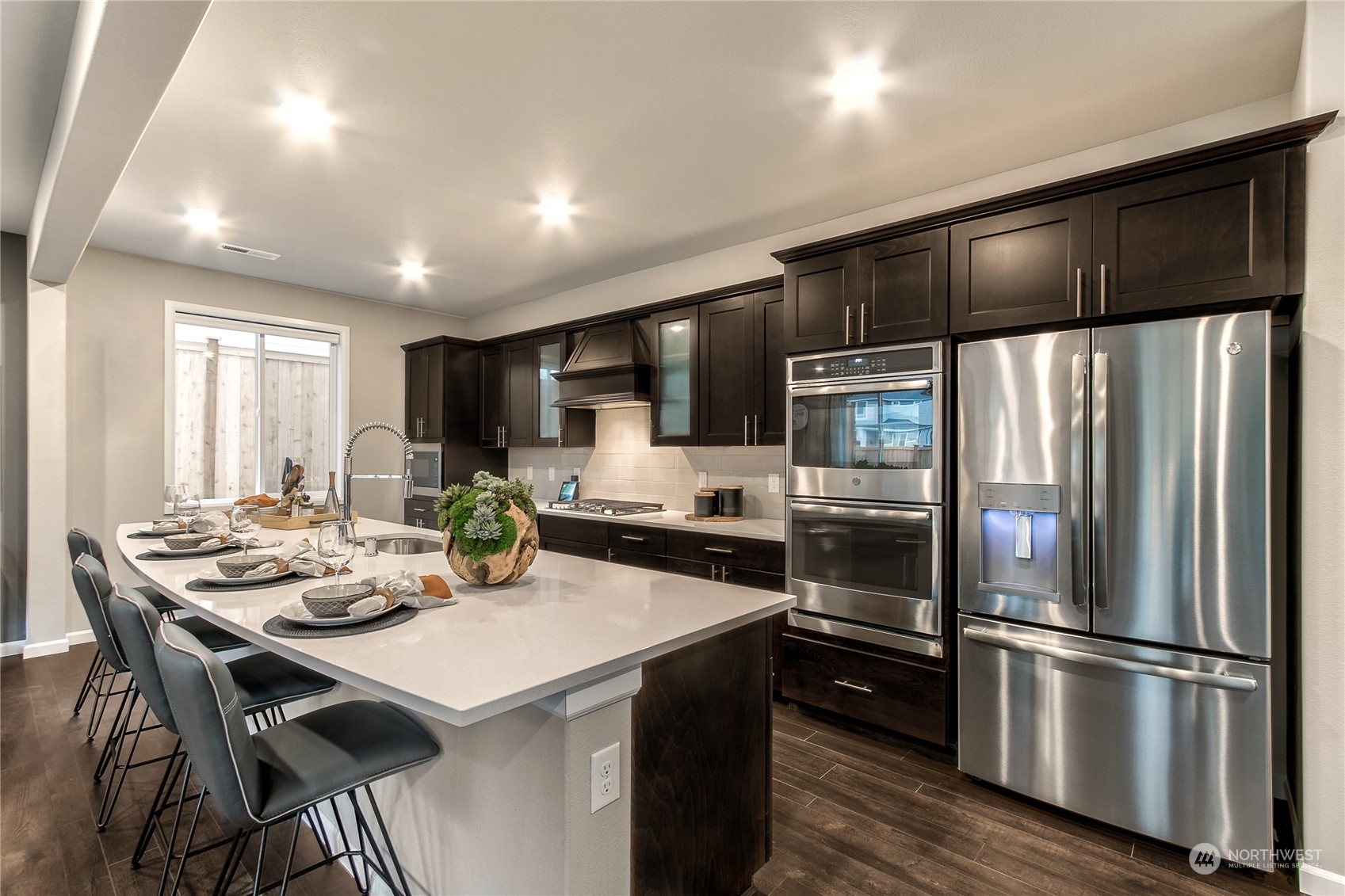 21116 42nd Drive Southeast, Unit 125 Bothell, WA 98021 - Photo 2 of 16 a kitchen with a refrigerator a stove a sink and chairs