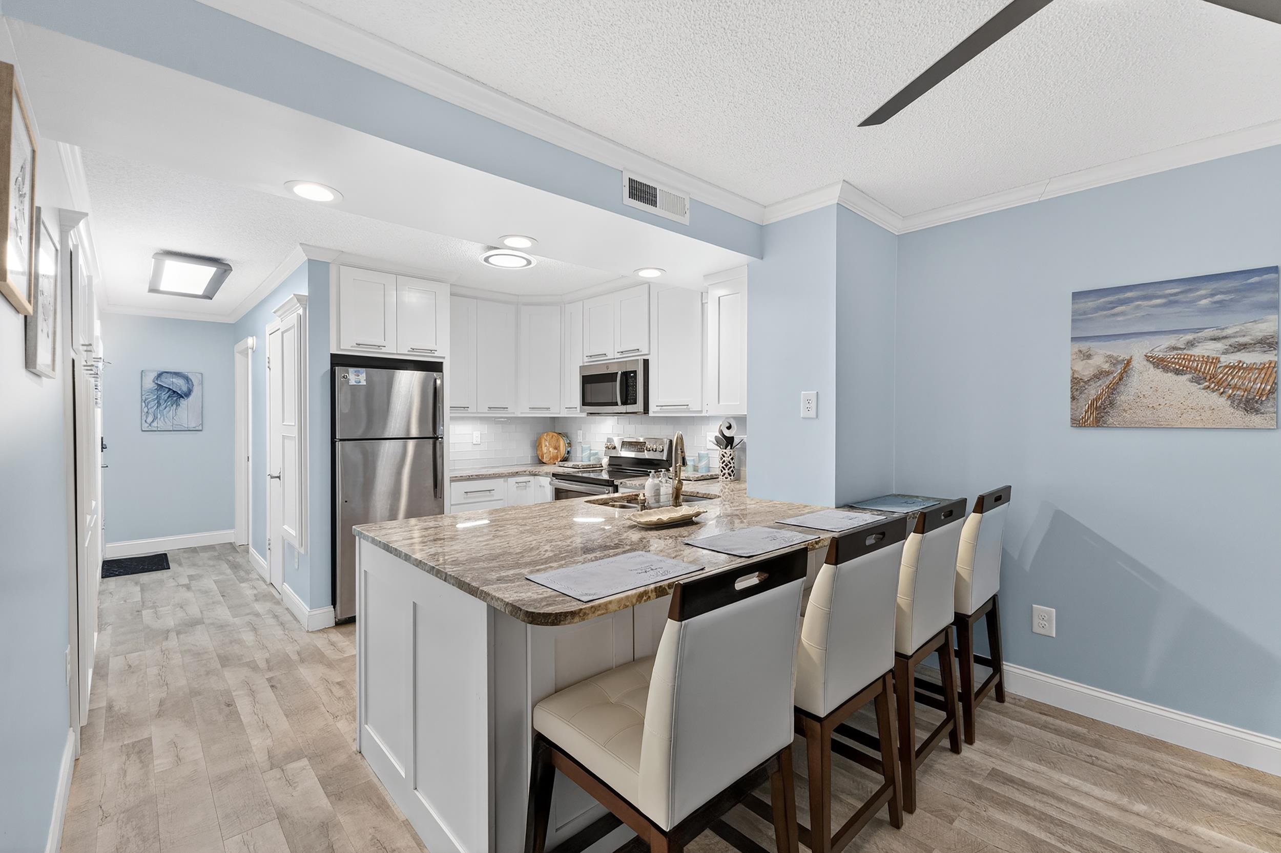 9581 Shore Drive, Unit 229 Myrtle Beach, SC 29572 - Photo 14 of 39 Kitchen featuring a kitchen breakfast bar, white cabinetry, appliances with stainless steel finishes, recessed lighting, and a peninsula