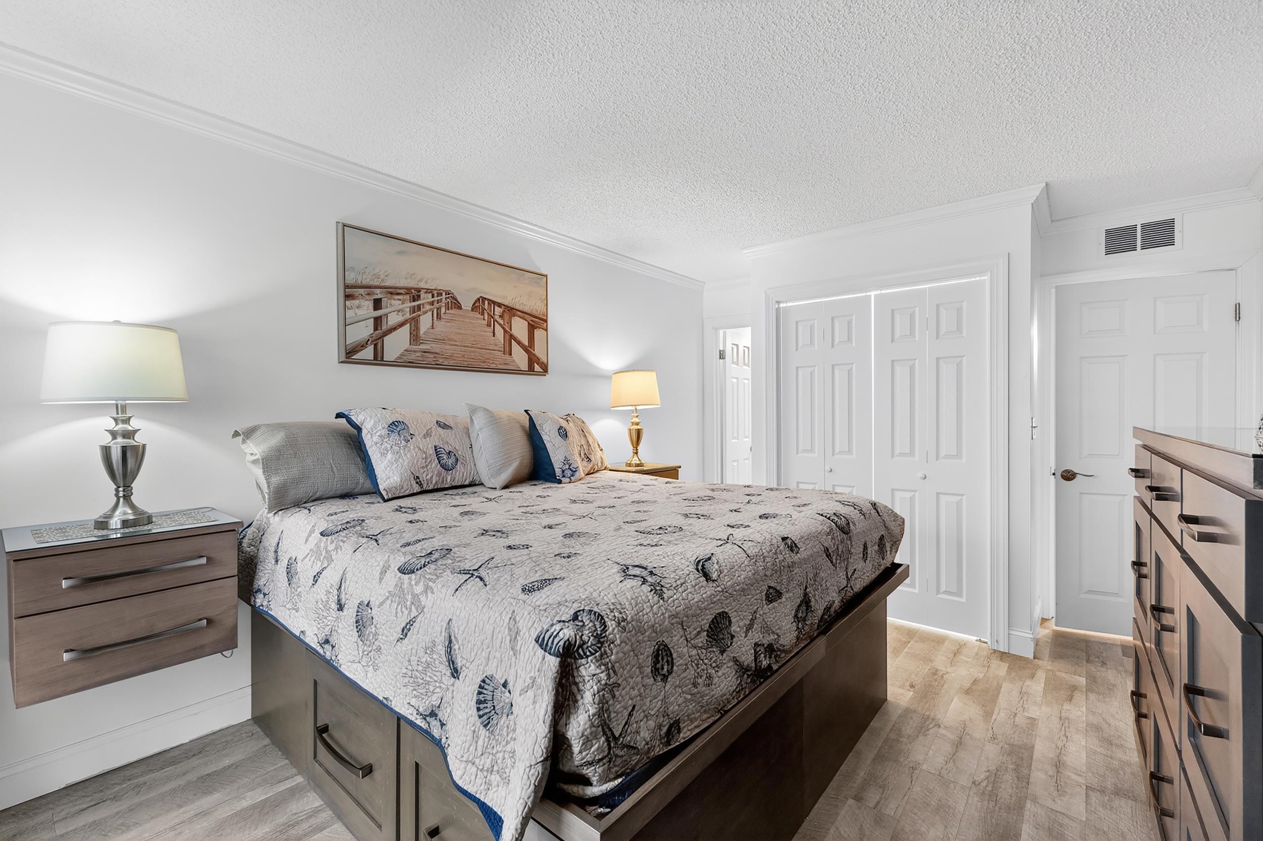 9581 Shore Drive, Unit 229 Myrtle Beach, SC 29572 - Photo 20 of 39 Bedroom featuring crown molding, a textured ceiling, light wood-style floors, and a closet