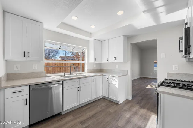 a kitchen with granite countertop cabinets a sink and appliances