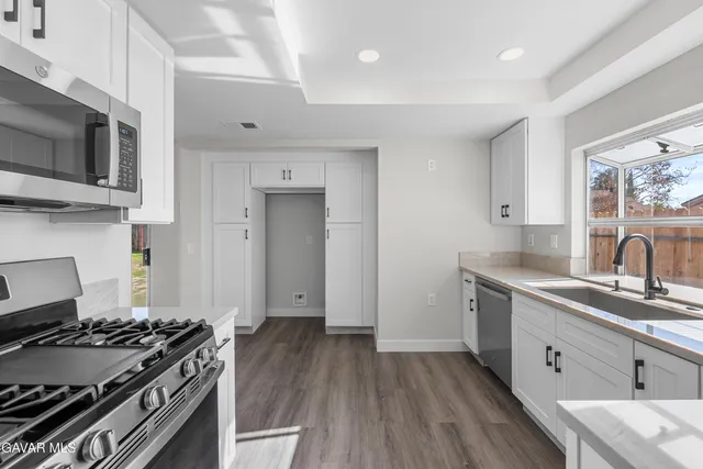 a kitchen with a sink stove and microwave