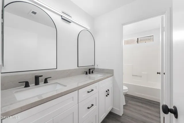 a bathroom with a granite countertop sink mirror and vanity
