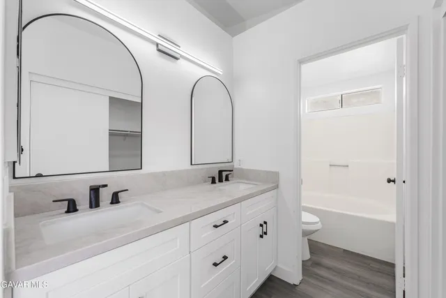 a bathroom with a double vanity sink and a mirror