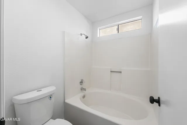 a white bath tub sitting next to a white toilet