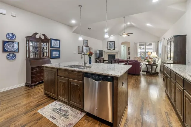 a kitchen with stainless steel appliances granite countertop a sink stove and wooden floor