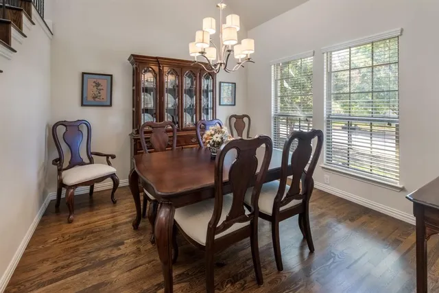 a view of a dining room with furniture a chandelier and wooden floor