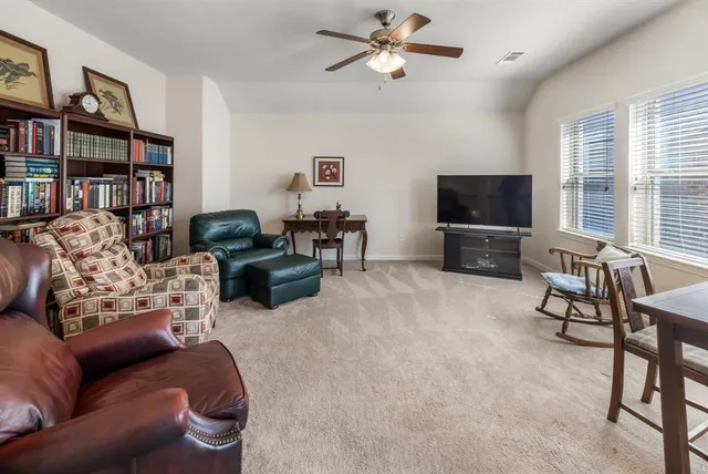 a living room with furniture a flat screen tv and a window