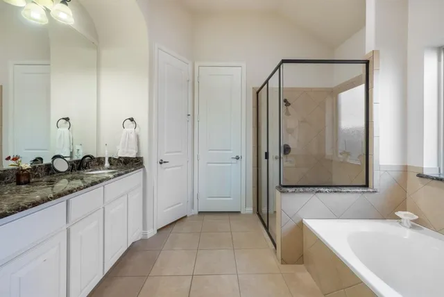 a bathroom with a tub sink and mirror