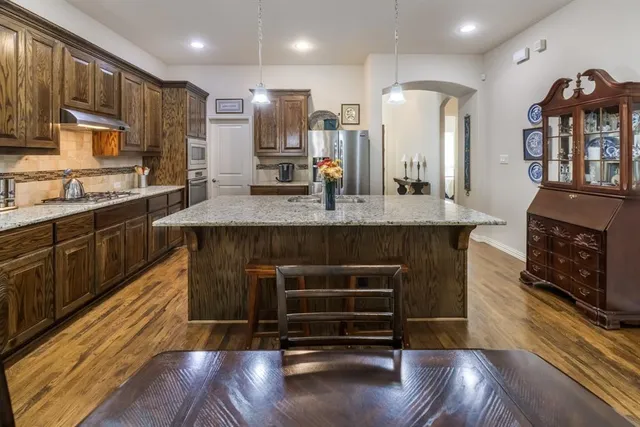 a kitchen with stainless steel appliances granite countertop a stove and a sink