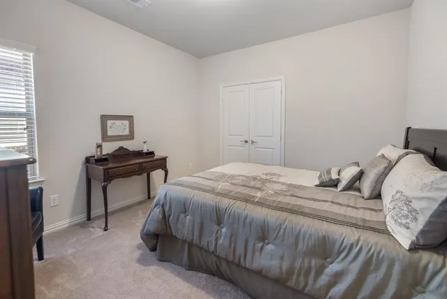 a bedroom with a bed and a table chair