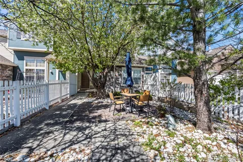 a view of backyard with a table and chairs and wooden fence