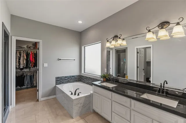 a spacious bathroom with a granite countertop sink and a mirror
