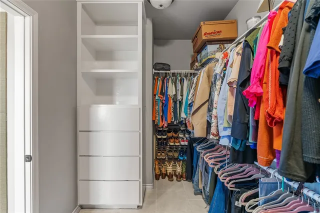 a view of walk in closet with clothes and shoes