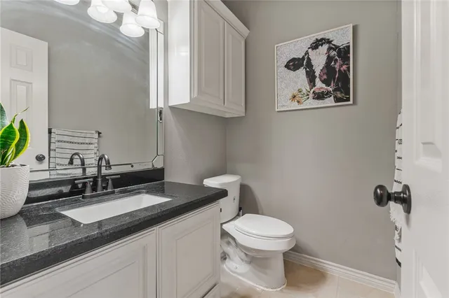 a bathroom with a granite countertop sink mirror vanity and toilet