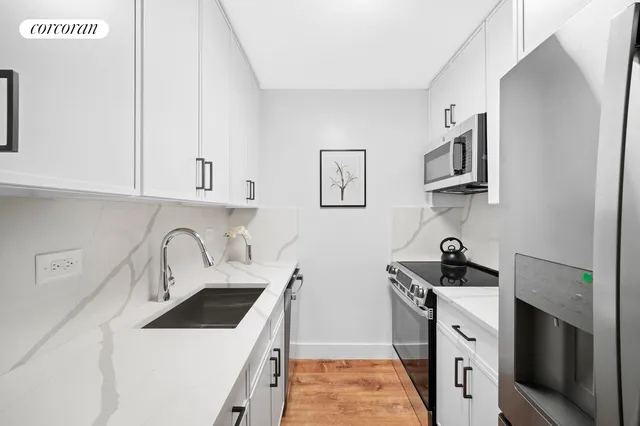 a kitchen with white cabinets sink and stainless steel appliances