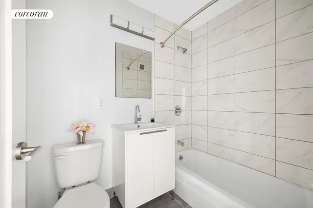 a bathroom with a bathtub shower sink mirror and toilet