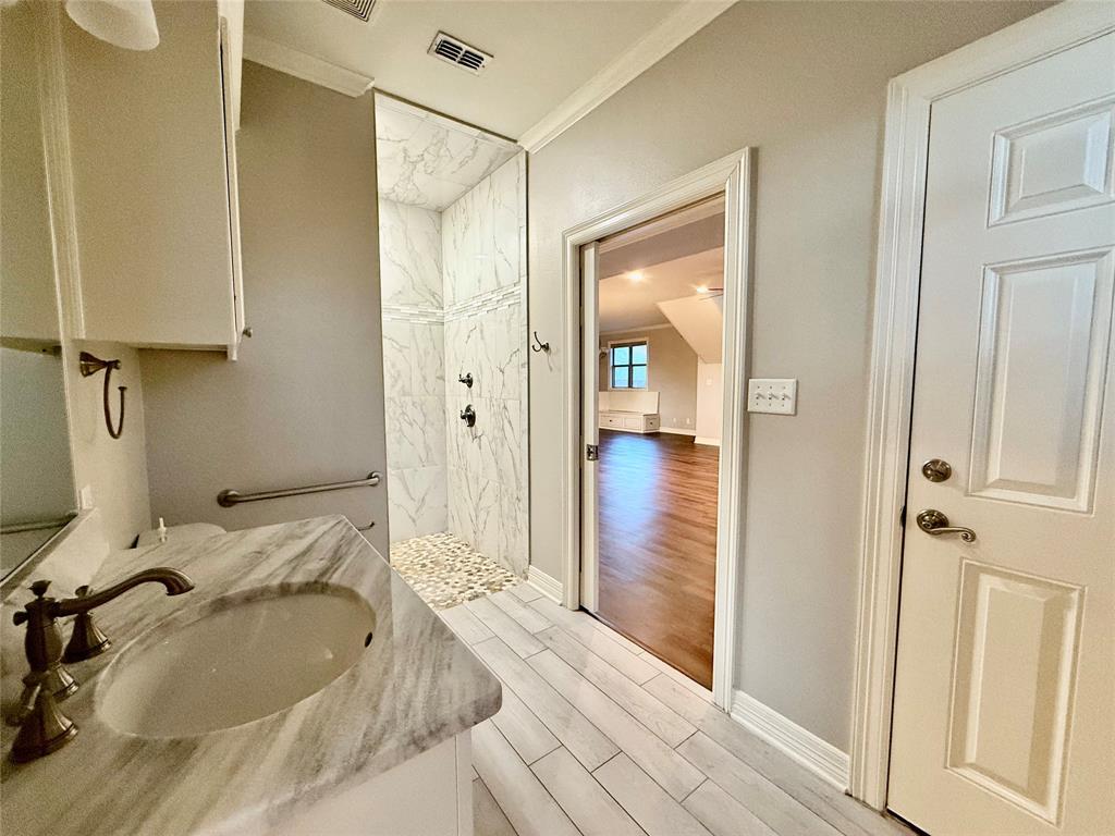 3815 Holly Ridge Drive, Unit GUEST Longview, TX 75605 - Photo 18 of 31 Bathroom featuring a marble finish shower, crown molding, vanity, and light wood-style flooring