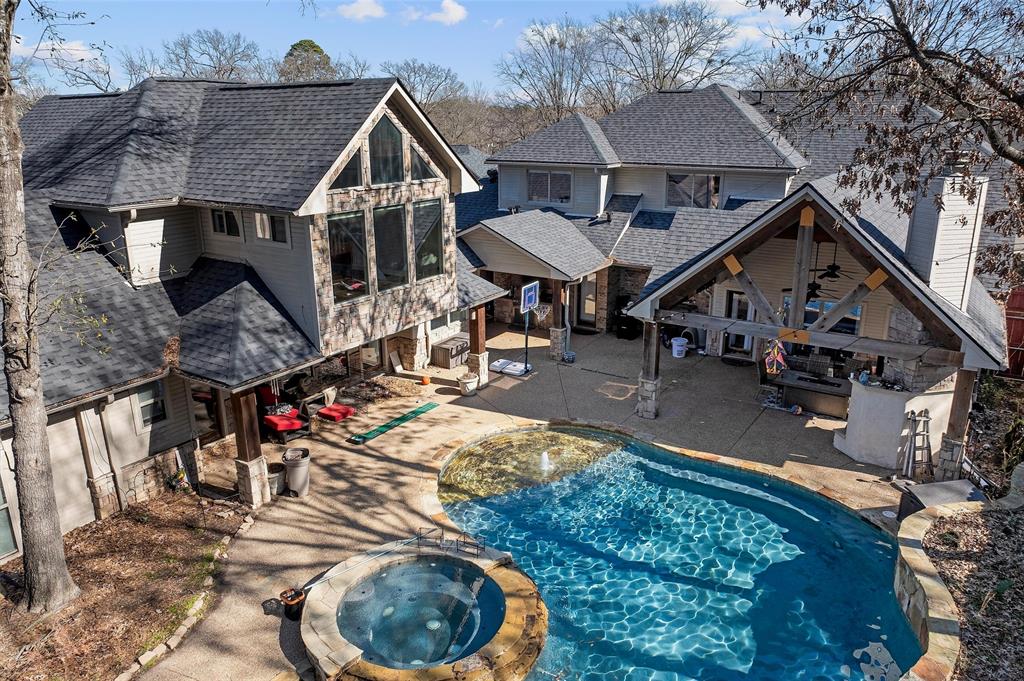 3815 Holly Ridge Drive, Unit GUEST Longview, TX 75605 - Photo 28 of 31 Back of property with a patio, roof with shingles, a pool with connected hot tub, and an outdoor kitchen