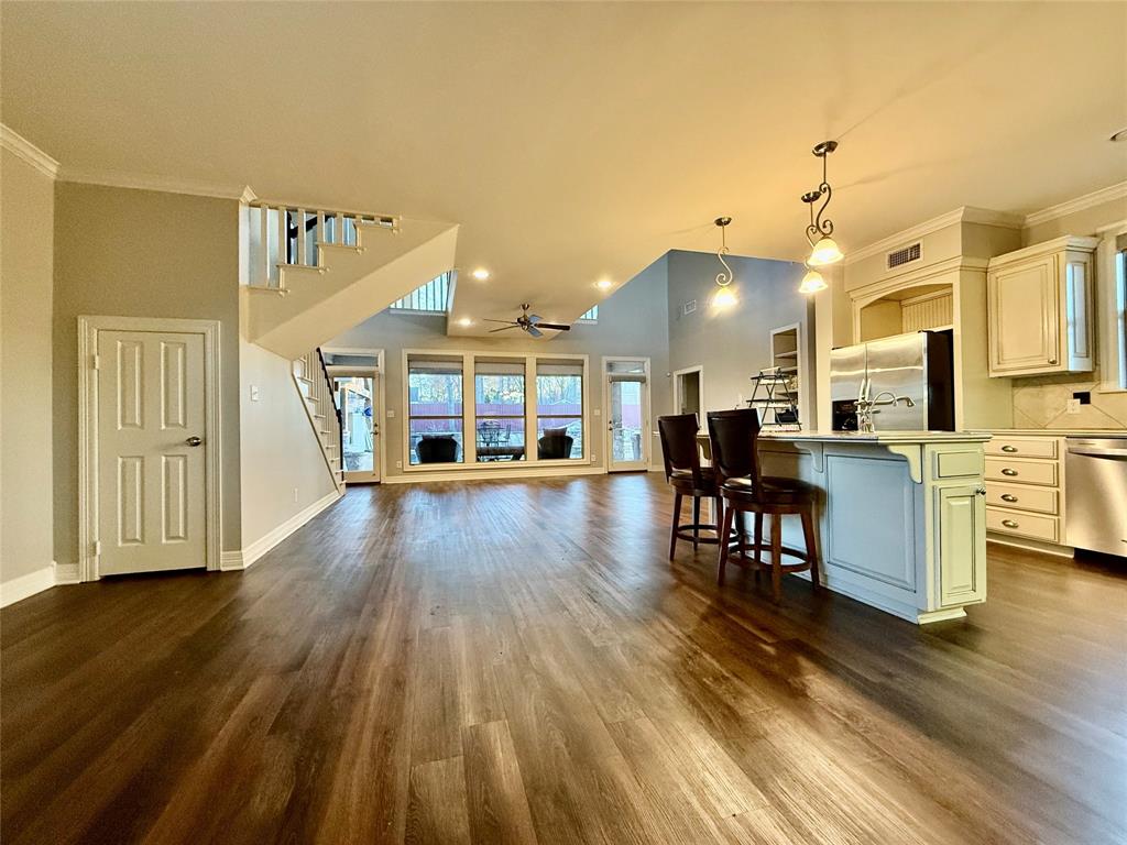 3815 Holly Ridge Drive, Unit GUEST Longview, TX 75605 - Photo 30 of 31 Kitchen with crown molding, open floor plan, pendant lighting, a kitchen island with sink, and a breakfast bar area