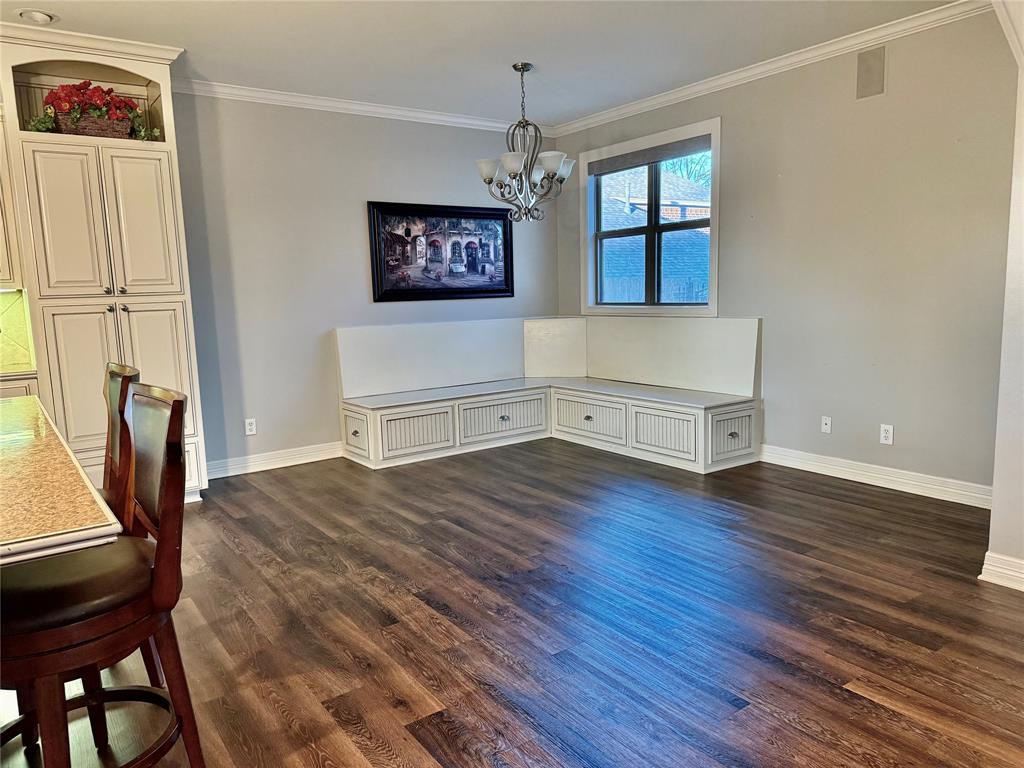 3815 Holly Ridge Drive, Unit GUEST Longview, TX 75605 - Photo 4 of 31 Unfurnished dining area with crown molding, dark wood-style floors, and a chandelier