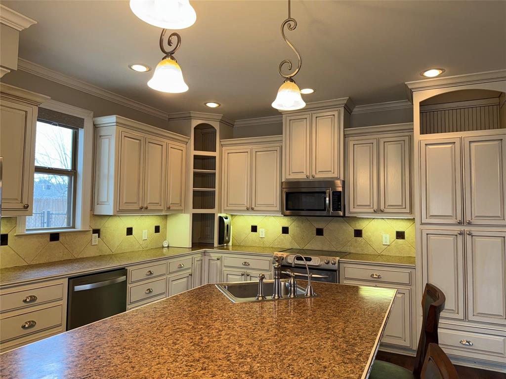 3815 Holly Ridge Drive, Unit GUEST Longview, TX 75605 - Photo 8 of 31 Kitchen with hanging light fixtures, stainless steel appliances, backsplash, crown molding, and open shelves
