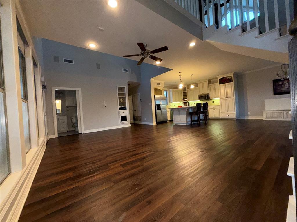 3815 Holly Ridge Drive, Unit GUEST Longview, TX 75605 - Photo 9 of 31 Unfurnished living room featuring a ceiling fan, a high ceiling, dark wood finished floors, and recessed lighting