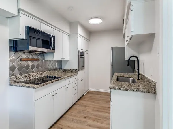 a kitchen with stainless steel appliances granite countertop a sink stove and microwave