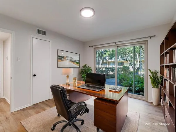 a view of a workspace with furniture and a window