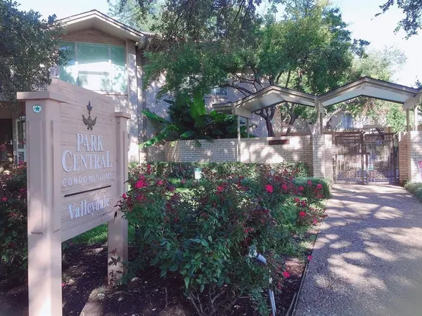 a view of a house with a yard and potted plants