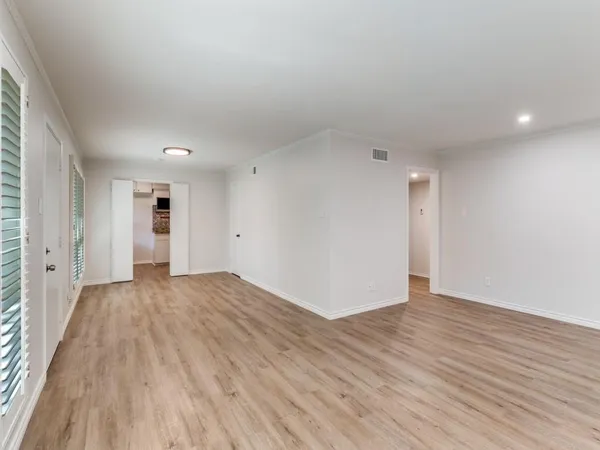 a view of empty room with wooden floor