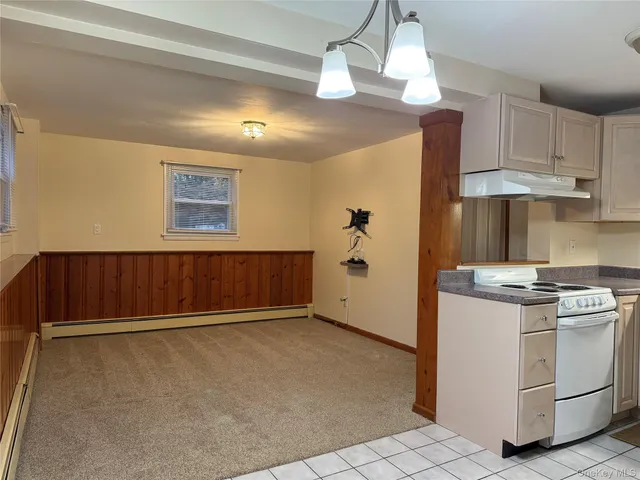 a view of kitchen with stove and cabinets