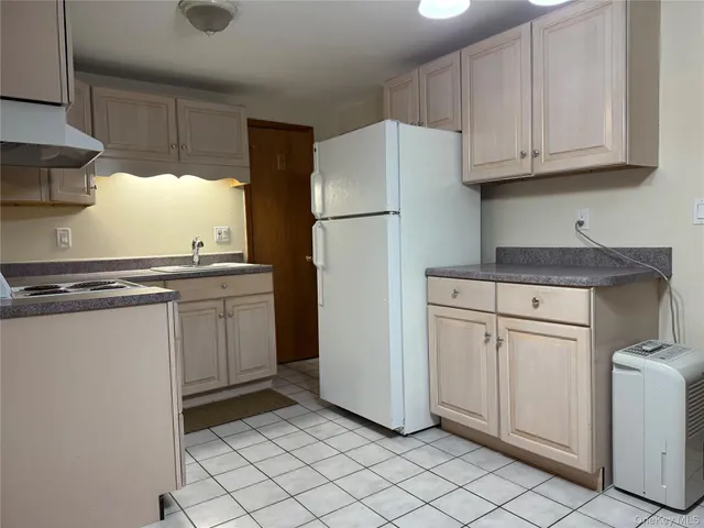 a kitchen with white cabinets and white appliances